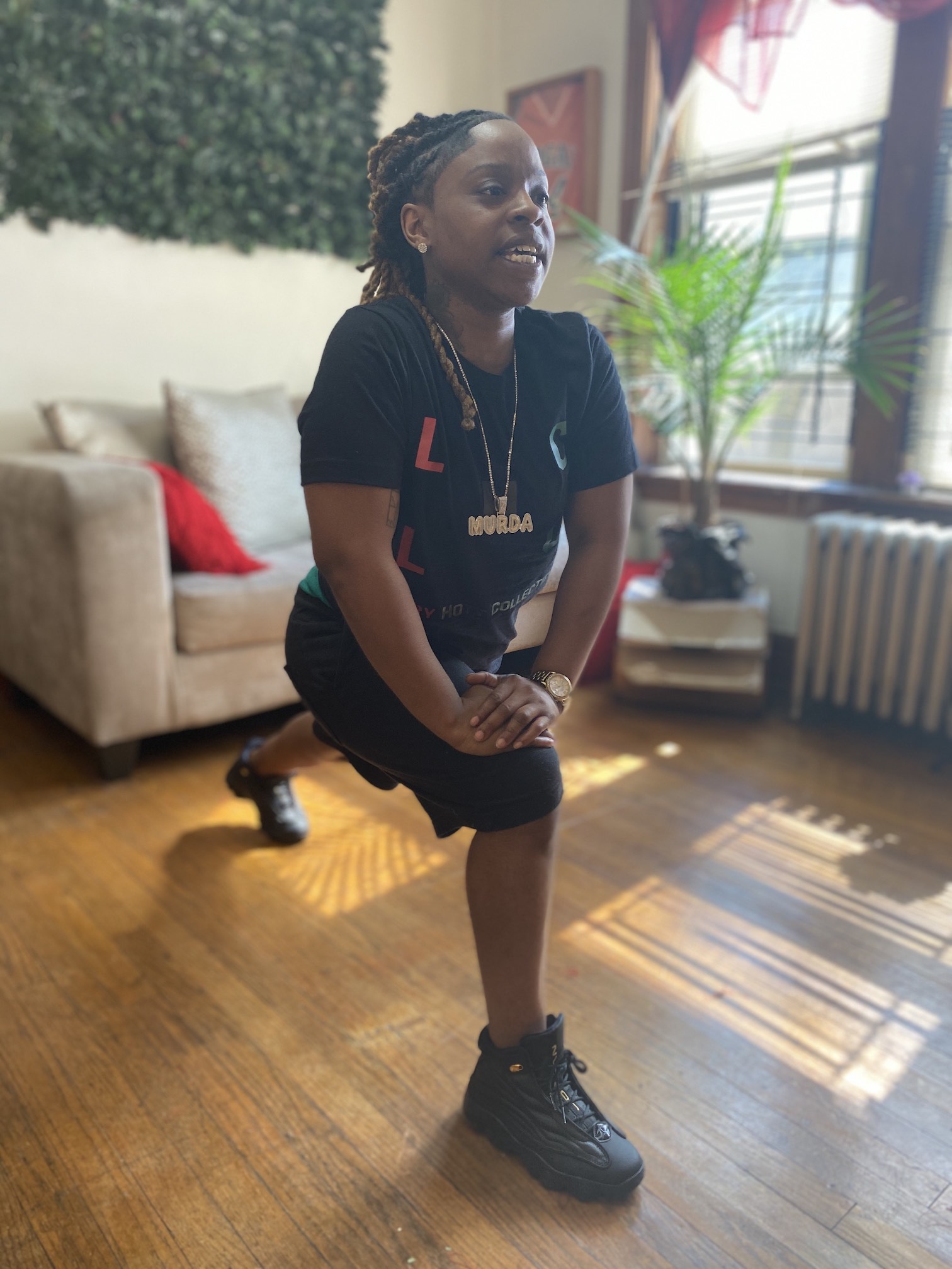 Woman stretching in a deep lunge, preparing to teach dance class in home setting